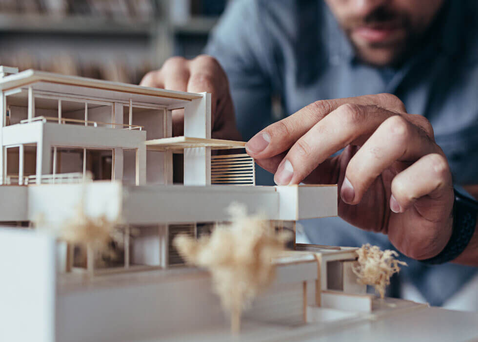 Architekturbüro: Architekt baut Miniaturmodel eines geplanten Haus